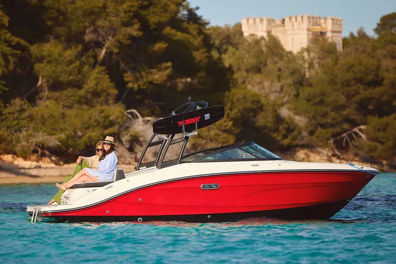 Slide: The Image of Manufacturer Provided Image: 2025 Sea Ray SPX 210 boat cruising on clear water near a forested shoreline. - 2