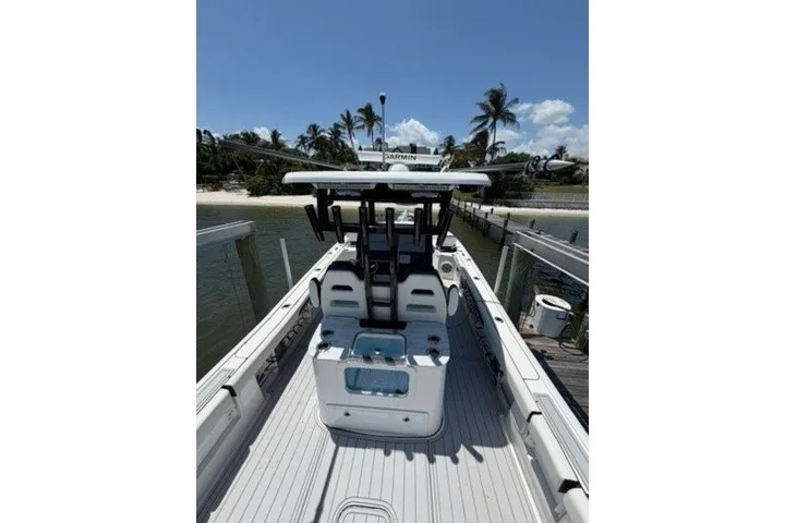 Slide: The Image of 2024 Tidewater 3100 Carolina Bay boat docked near palm trees under clear sky. - 16
