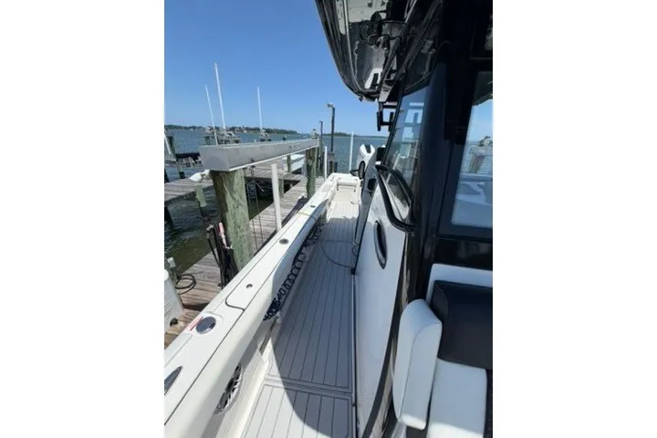 Slide: The Image of 2024 Tidewater 3100 Carolina Bay boat docked at marina, showcasing sleek design and spacious deck. - 17