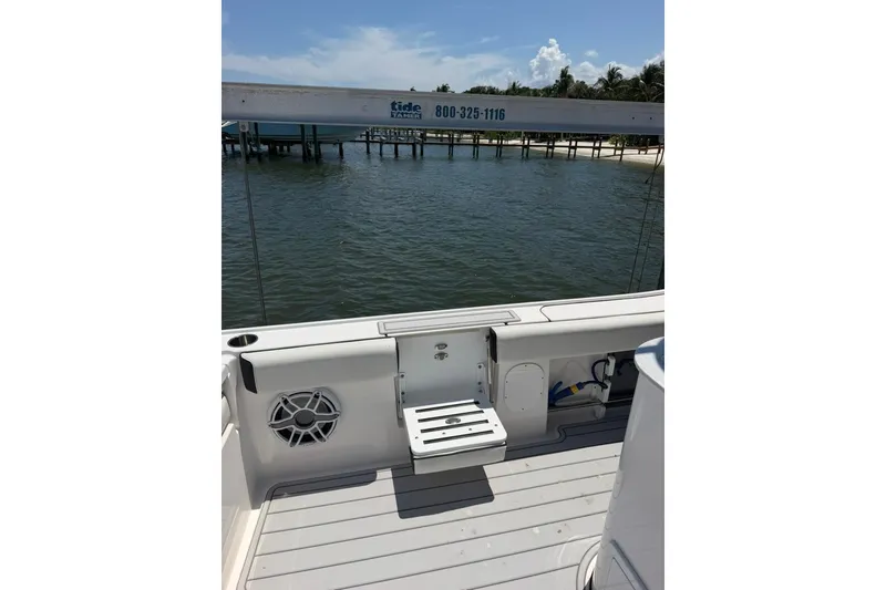 Slide: The Image of 2024 Tidewater 3100 Carolina Bay boat deck with seating, overlooking calm waters and a pier. - 23