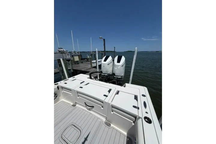 Slide: The Image of 2024 Tidewater 3100 Carolina Bay boat docked, featuring dual outboard engines. - 14