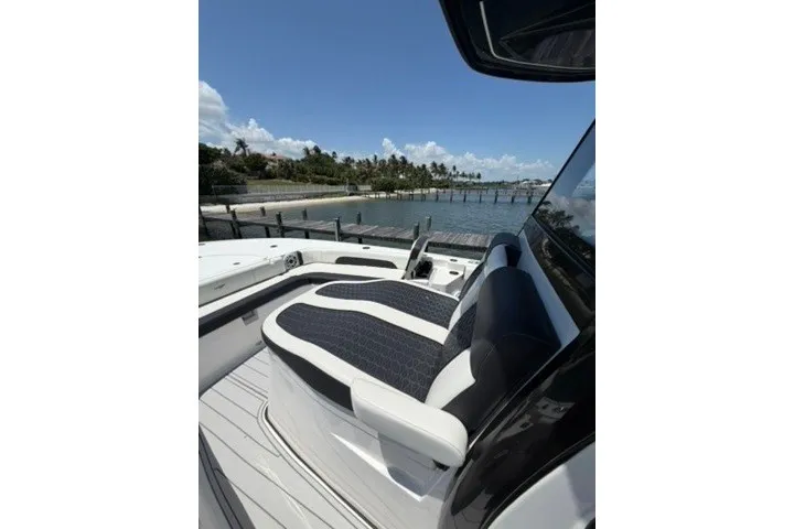 Slide: The Image of 2024 Tidewater 3100 Carolina Bay boat with sleek seating, docked by a scenic waterfront. - 25