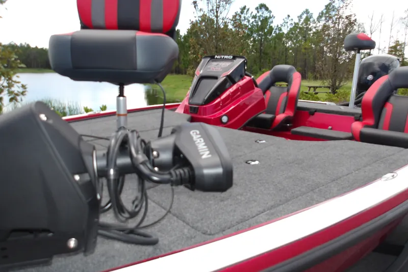 Slide: The Image of 2027 Nitro Z18 XL Pro boat with Garmin equipment, red and black seating, near a lake. - 16