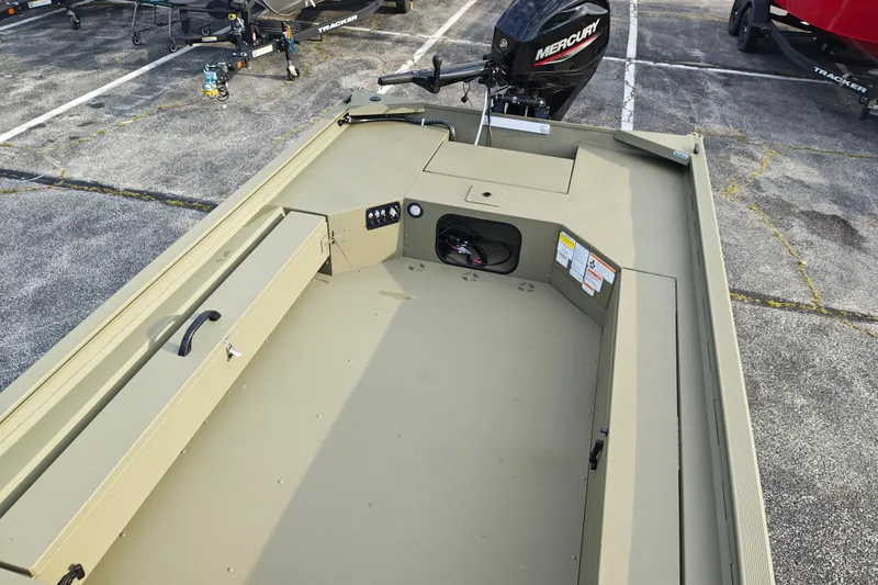 Slide: The Image of 2027 Tracker Grizzly 1654 T Sportsman boat interior with Mercury engine, parked on asphalt. - 13