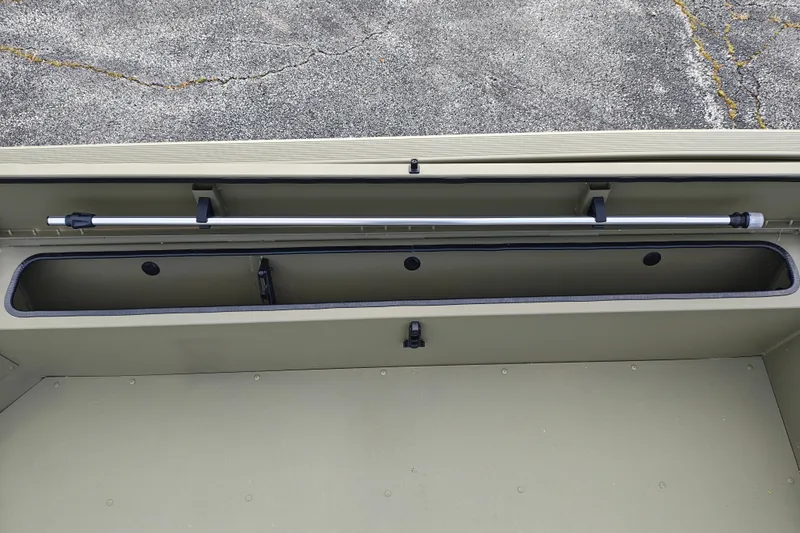 Slide: The Image of 2027 Tracker Grizzly 1654 T Sportsman boat storage compartment with rod holder. - 17