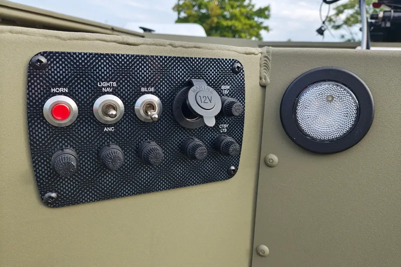 Slide: The Image of Control panel of 2027 Tracker Grizzly 1654 T Sportsman boat with switches and 12V outlet. - 22