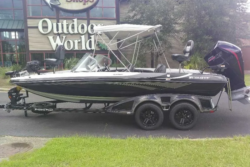 Slide: The Image of 2026 Ranger 212LS boat parked outside Outdoor World store. - 14