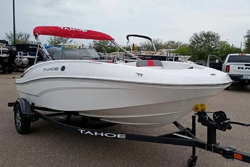 The Image of 2026 Tahoe T16 boat with red canopy on trailer in parking lot. - 0