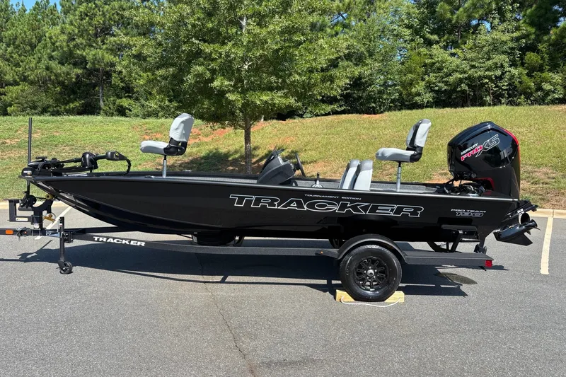 The Image of 2027 Tracker Pro Team 190 boat on trailer, parked outdoors with trees in background. - 0