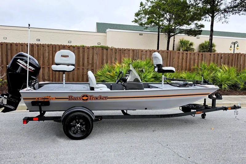 The Image of 2027 Tracker Bass Tracker Classic Limited fishing boat on trailer, parked outdoors. - 0