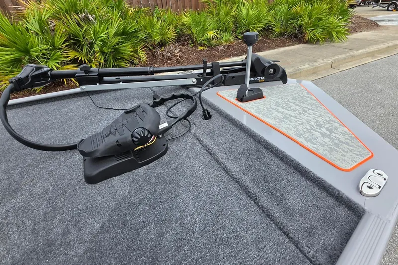 Slide: The Image of 2027 Tracker Bass Tracker Classic Limited boat deck with trolling motor and lush greenery. - 18