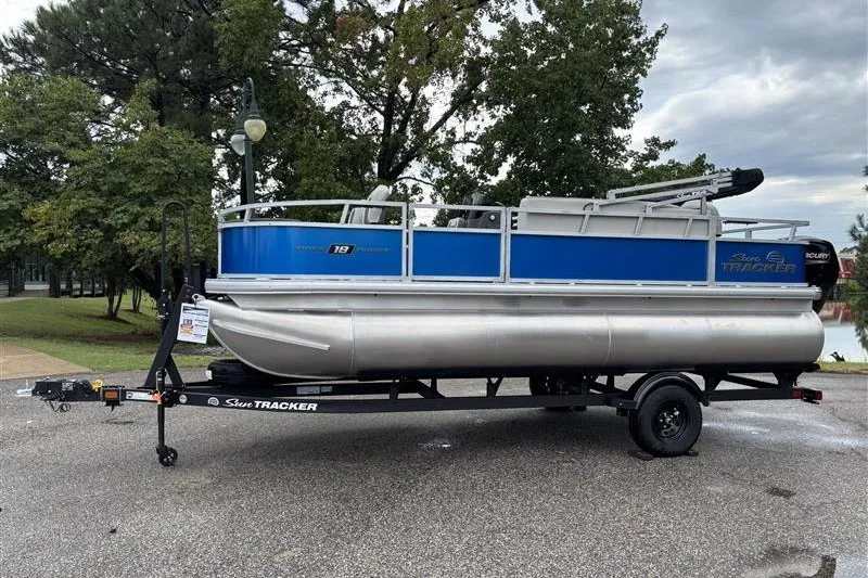 The Image of 2027 Sun Tracker Bass Buggy 18 DLX pontoon boat on trailer, parked outdoors. - 0