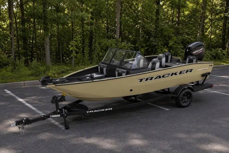 The Image of 2027 Tracker Pro Guide V-175 Combo boat on trailer in wooded parking area. - 0