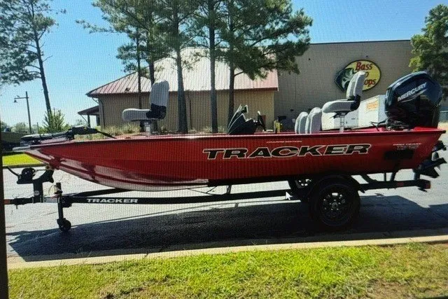 The Image of 2027 Tracker Pro Team 175 Crappie Edition boat in red, parked outside Bass Pro Shops. - 0
