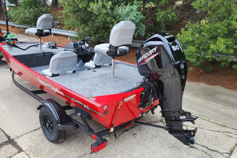 Slide: The Image of Red 2027 Tracker Bass Tracker Classic XL boat with Mercury 50 engine, parked outdoors. - 51