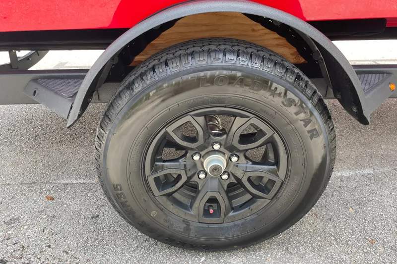 Slide: The Image of Black wheel and tire of a 2027 Tahoe T18 trailer on asphalt. - 10