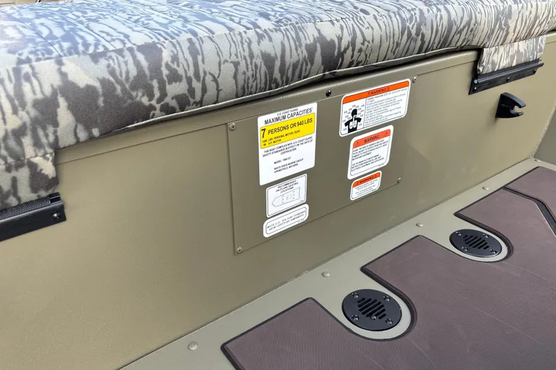 Slide: The Image of 2027 Tracker Grizzly 1860 CC boat interior with seating and safety labels. - 19