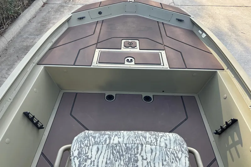 Slide: The Image of 2027 Tracker Grizzly 1860 CC boat interior with camo seat and storage compartments. - 13