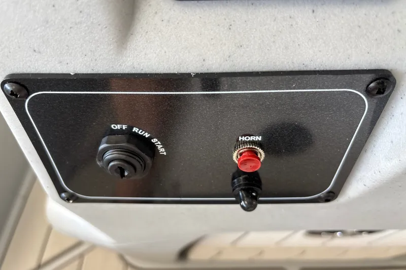Slide: The Image of Control panel of 2027 Tracker Bass Tracker Classic CC with ignition and horn buttons. - 20