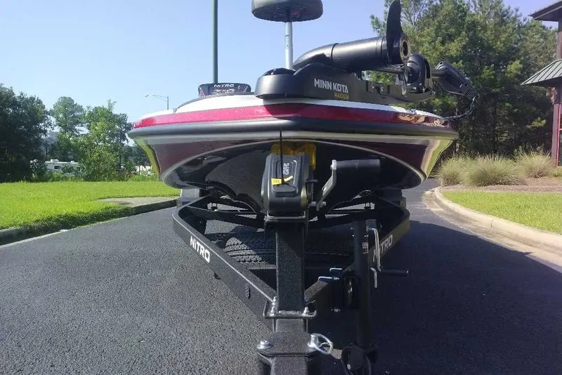 Slide: The Image of 2027 Nitro Z18 XL boat on trailer, featuring Minn Kota motor, parked on asphalt. - 4