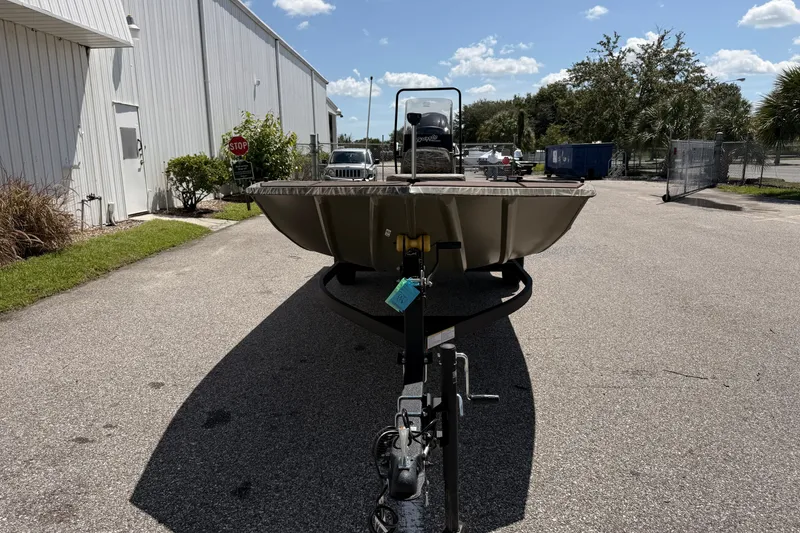 Slide: The Image of 2027 Tracker Grizzly 1860 CC boat on trailer, parked outdoors under a clear sky. - 62