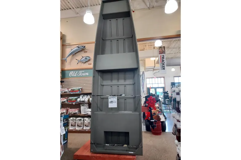 The Image of 2027 Tracker Grizzly 14 Jon boat displayed in a store with fishing gear. - 0