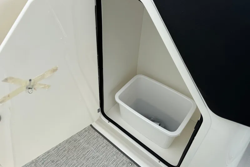 Slide: The Image of Storage compartment with bin in 2027 Sea Ray SLX 260 boat interior. - 13