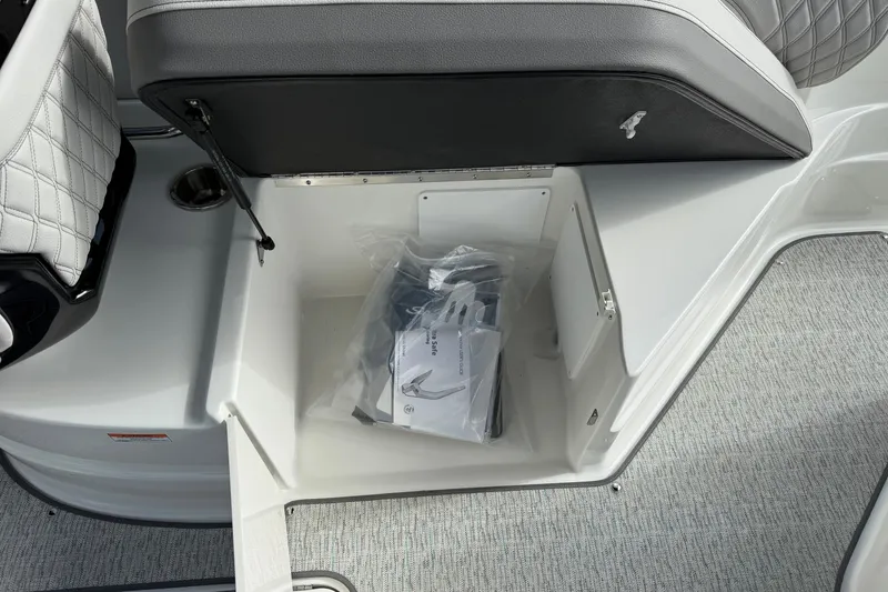 Slide: The Image of 2027 Sea Ray SLX 260 boat storage compartment with seat and accessories. - 20