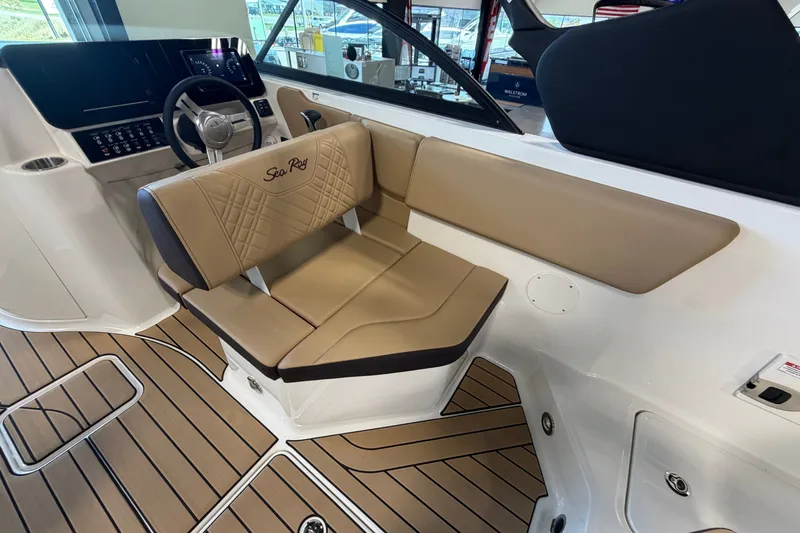Slide: The Image of 2027 Sea Ray SDX 230 boat interior with tan seating and modern dashboard design. - 14