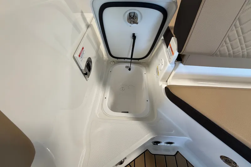 Slide: The Image of 2027 Sea Ray SDX 230 boat storage compartment with open hatch and seating area. - 15