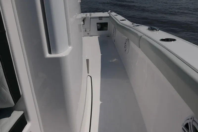 Slide: The Image of 2027 Blackfin 242 HB boat interior with sleek white design and ocean backdrop. - 21