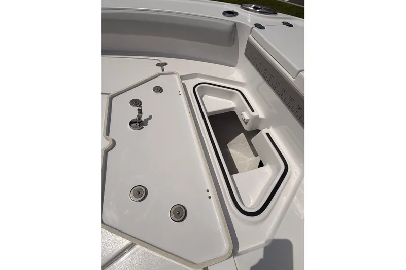 Slide: The Image of 2027 Blackfin 242 HB boat storage compartment with open hatch and measuring ruler. - 45