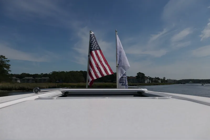Slide: The Image of American flag on a 2027 Blackfin 242 HB boat, cruising on a serene waterway. - 48