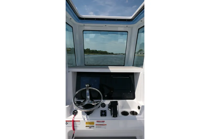 Slide: The Image of Interior view of 2027 Blackfin 242 HB boat cockpit with steering wheel and controls. - 27