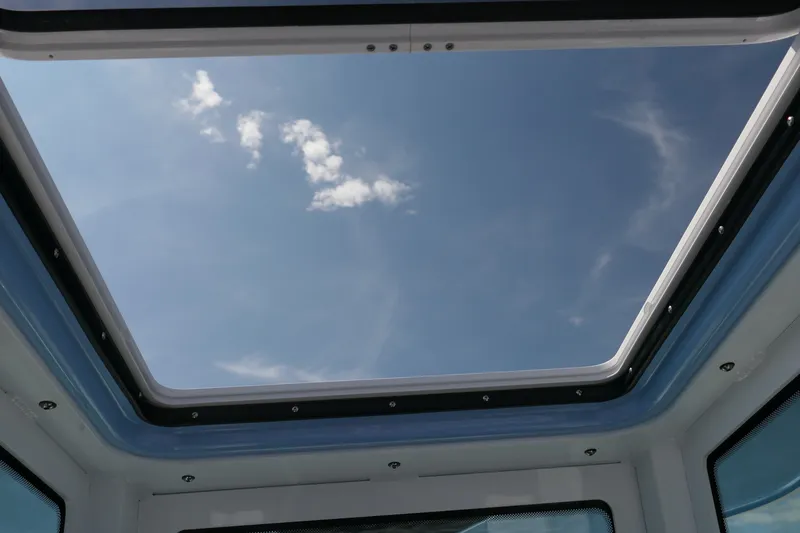 Slide: The Image of View through the sunroof of a 2027 Blackfin 242 HB boat, showcasing a clear blue sky. - 29