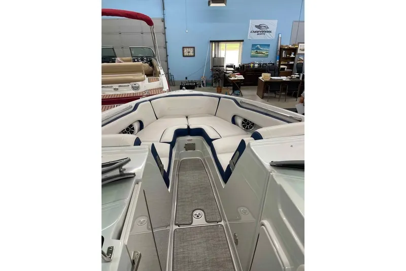 Slide: The Image of 2021 Crownline 255 SS boat interior with white and blue seating in showroom. - 10