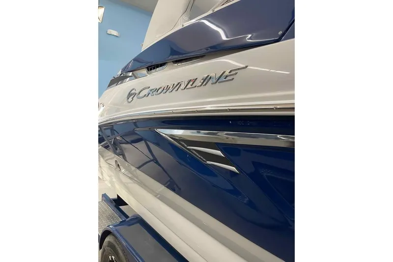Slide: The Image of 2021 Crownline 255 SS boat, blue and white exterior, close-up view. - 1