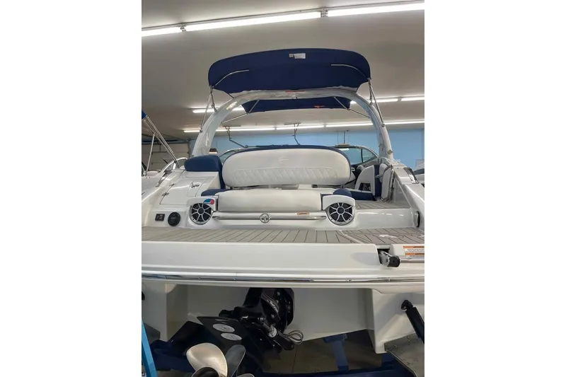 Slide: The Image of 2021 Crownline 255 SS boat interior with speakers and seating, under showroom lighting. - 5