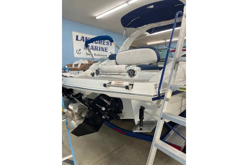 Slide: The Image of 2021 Crownline 255 SS boat in showroom with visible engine and seating. - 2