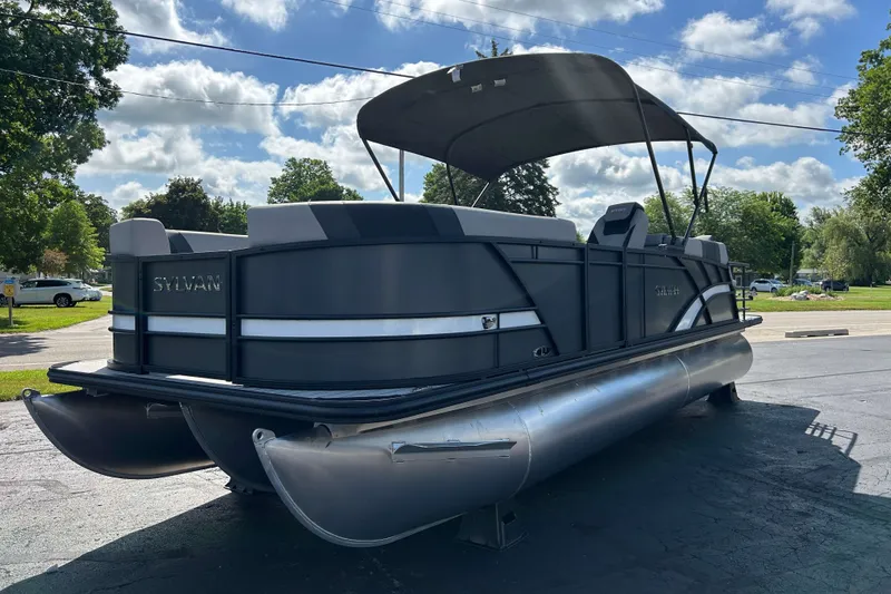 Slide: The Image of 2026 Sylvan L3 LZ Tritoon boat with canopy, parked outdoors on a sunny day. - 23