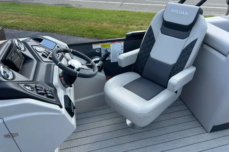 Slide: The Image of Captain's chair and helm of 2026 Sylvan L3 LZ Tritoon boat, featuring modern controls. - 11
