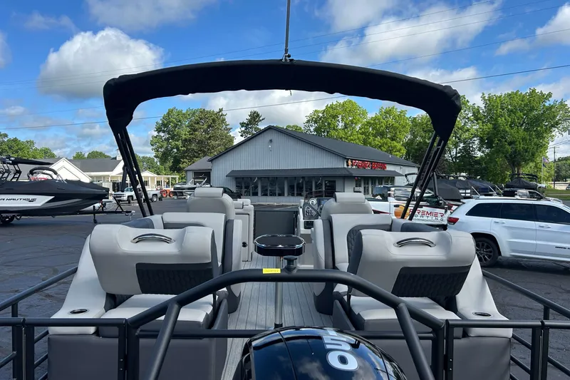 Slide: The Image of 2026 Sylvan L3 LZ Tritoon boat with seating, parked outdoors under a blue sky. - 2
