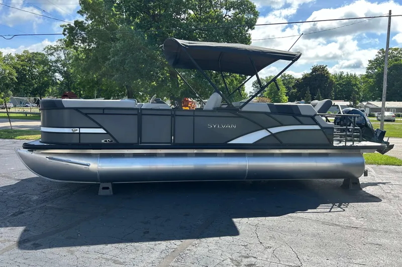 Slide: The Image of 2026 Sylvan L3 LZ Tritoon boat with canopy, parked outdoors on a sunny day. - 22