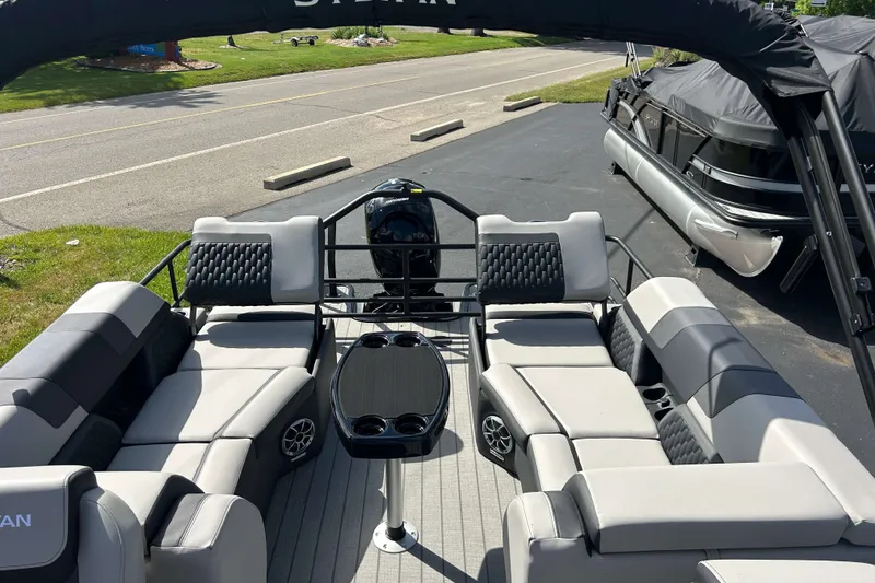 Slide: The Image of 2026 Sylvan L3 LZ Tritoon boat interior with plush seating and central table. - 9
