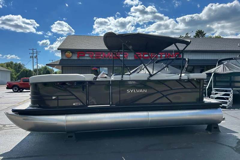 Slide: The Image of 2026 Sylvan Mirage 820 Cruise pontoon boat at dealership under blue sky. - 13