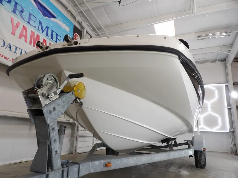 Slide: The Image of 2013 Bayliner 190 Deck Boat on a trailer inside a warehouse. - 5