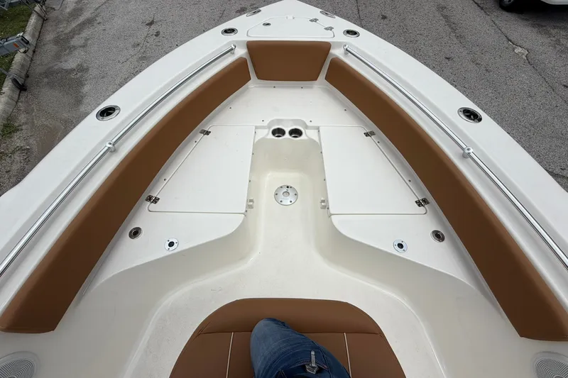 Slide: The Image of 2025 Key West 219 FS boat interior with brown seating and storage compartments. - 5