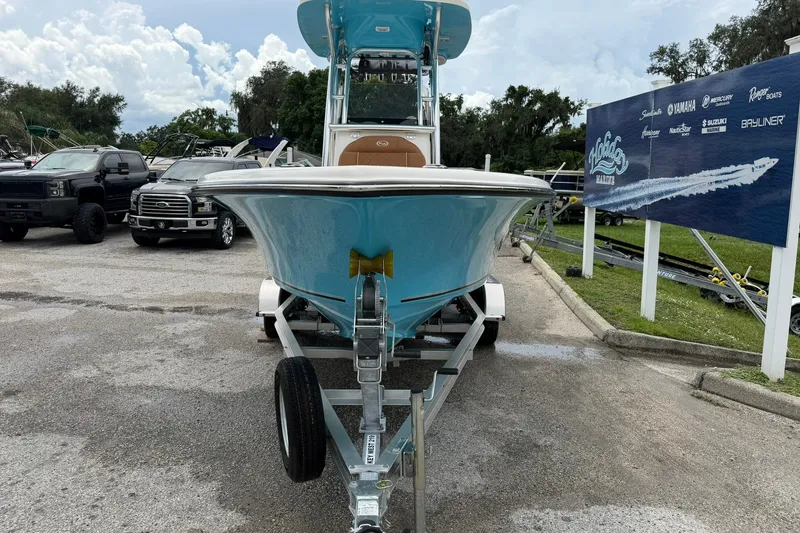 Slide: The Image of 2025 Key West 219 FS boat on trailer at dealership, surrounded by trucks and signage. - 36