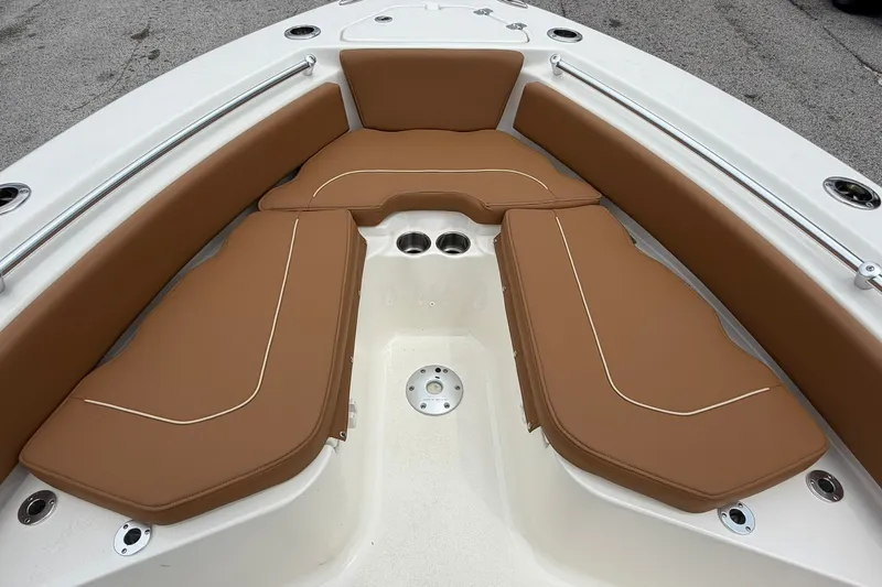 Slide: The Image of 2025 Key West 219 FS boat interior with brown cushioned seating and stainless steel cup holders. - 4