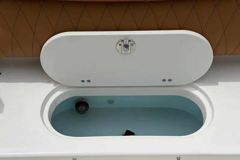 Slide: The Image of Open storage compartment on 2025 Key West 219 FS boat with cushioned seating. - 14